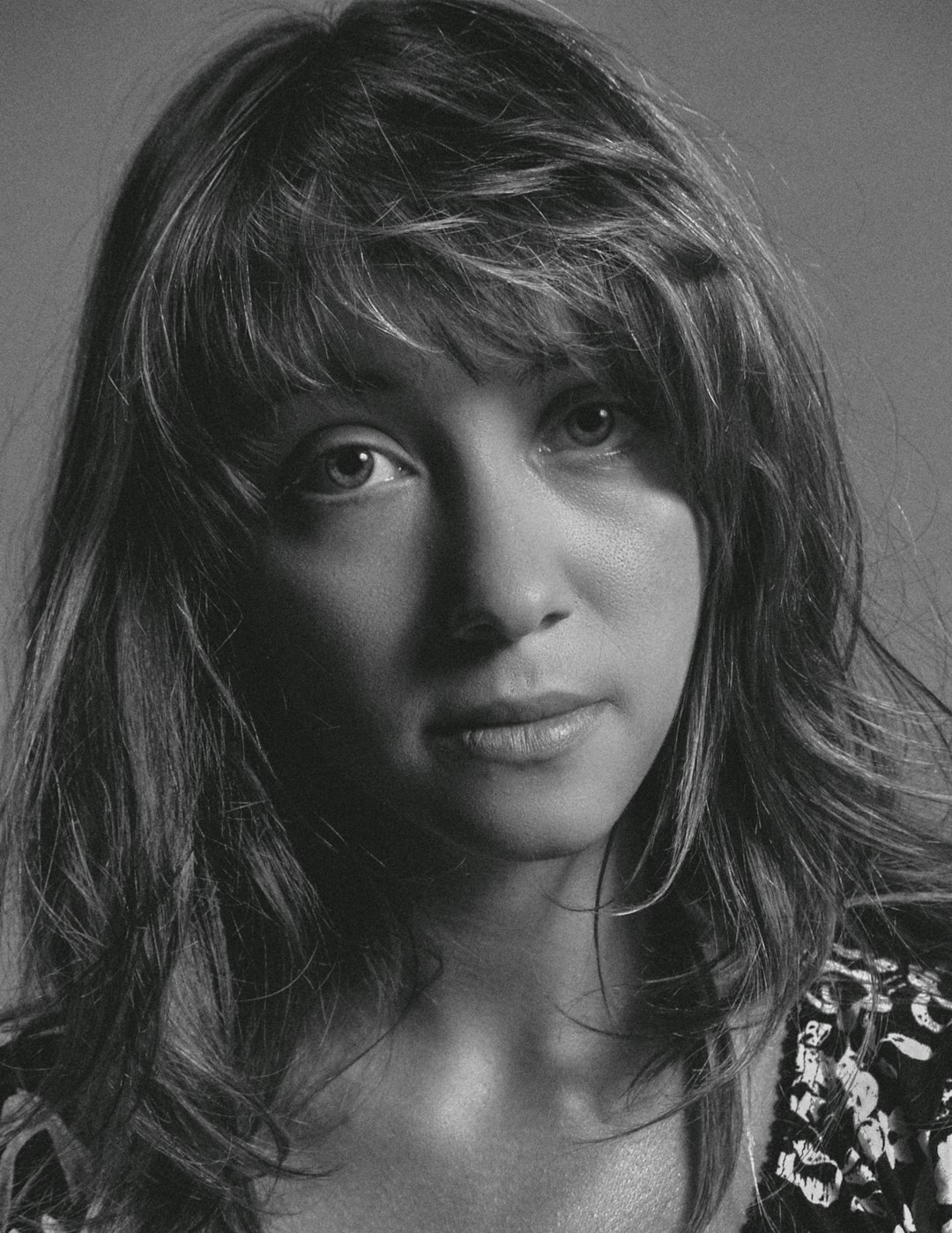 Woman with soft wispy bangs and long layered hair