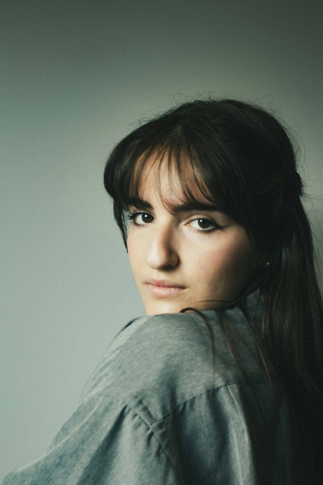 Woman with longer wispy bangs blended into layered hair