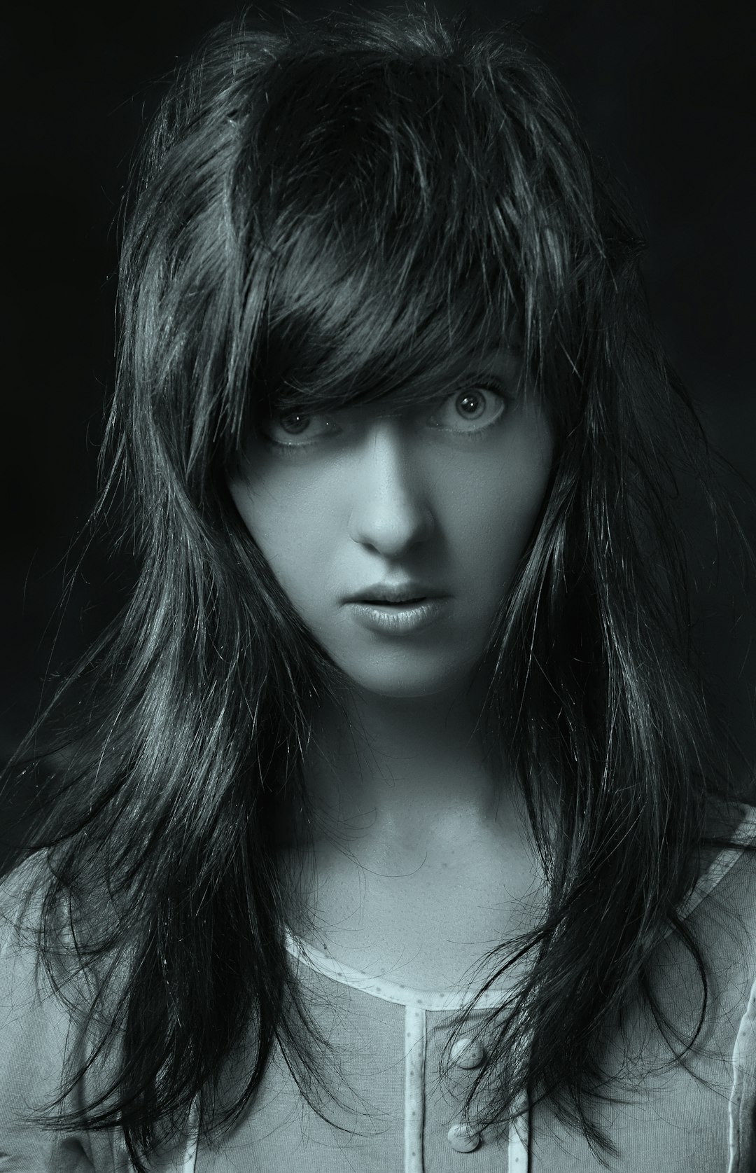 Woman with textured hair and light wispy bangs
